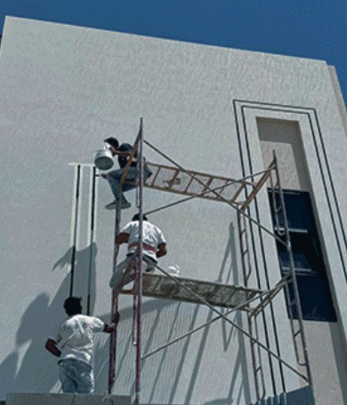 عامل على السقالة أثناء التشطيب الخارجي